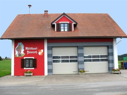 Rüsthaus der FF Prarath, großes Haus mit großen Garagentoren in grau - rote Wandfarbe